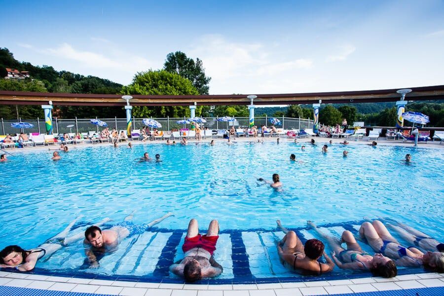 Kupači na podvodnim masažnim ležaljkama u vanjskom bazenu